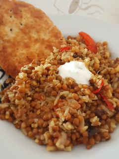 Una foto de Mujaddara con pimiento y salsa de yogur