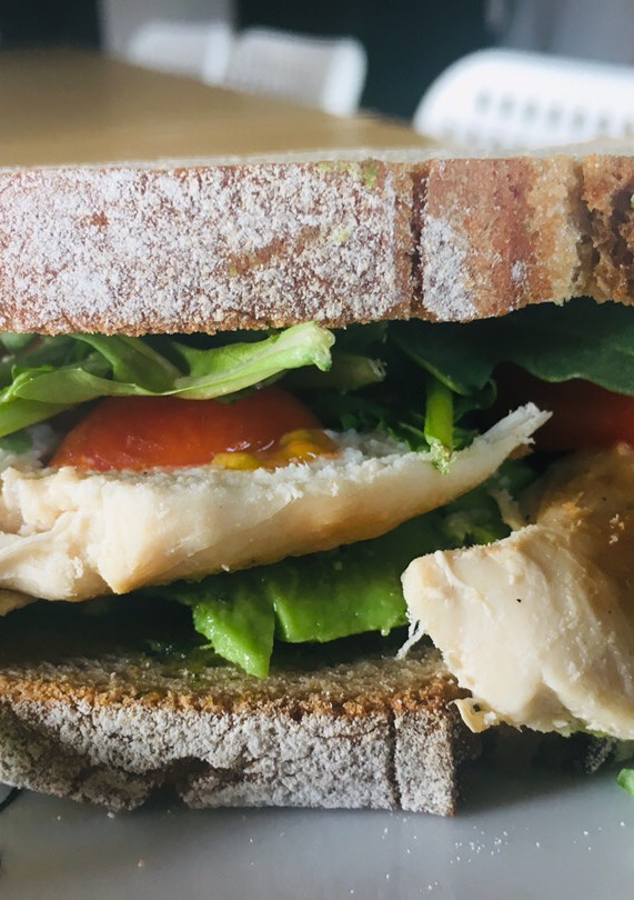 Una foto de Sandwich de pollo con aguacate y pesto de rúcula