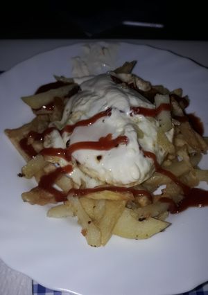 Una foto de Patatas fritas con huevo y salsa