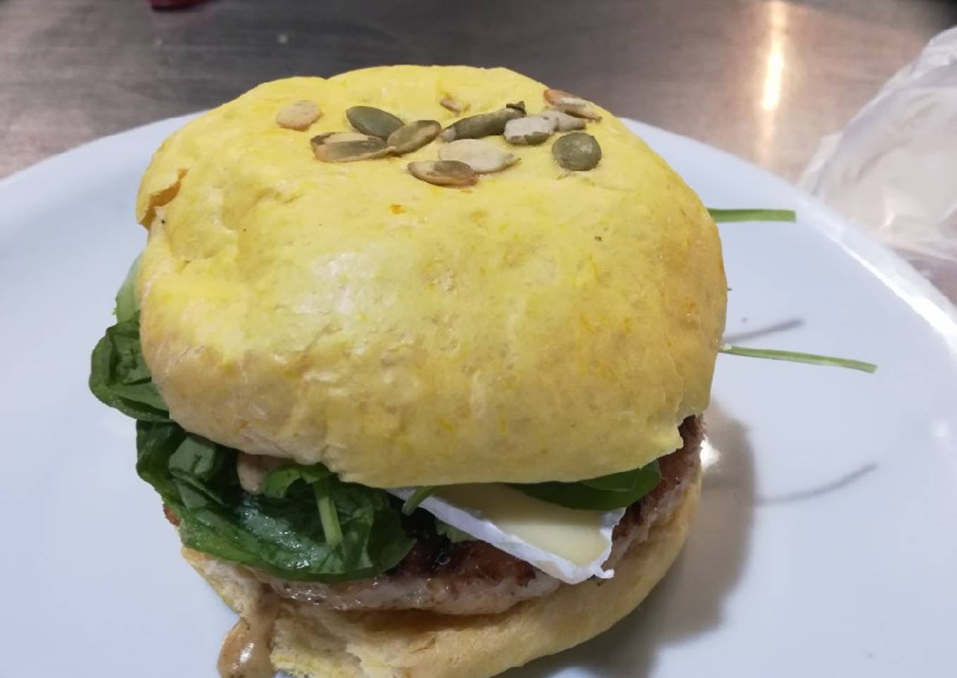 Hamburguesa de pollo al curry con palta, rúcula y brie