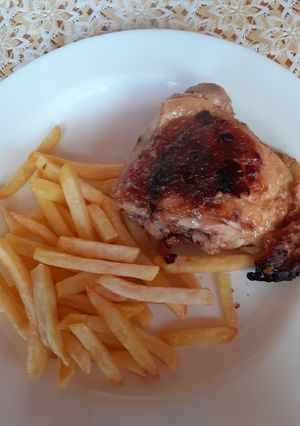Una foto de Pollo asado con mostaza, limón y papitas fritas