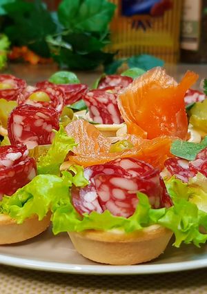 Фото Вкусные праздничные закуски в готовых песочных тарталетках и бутерброды.