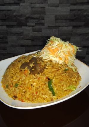 A picture of Jollof rice and fresh veggie.