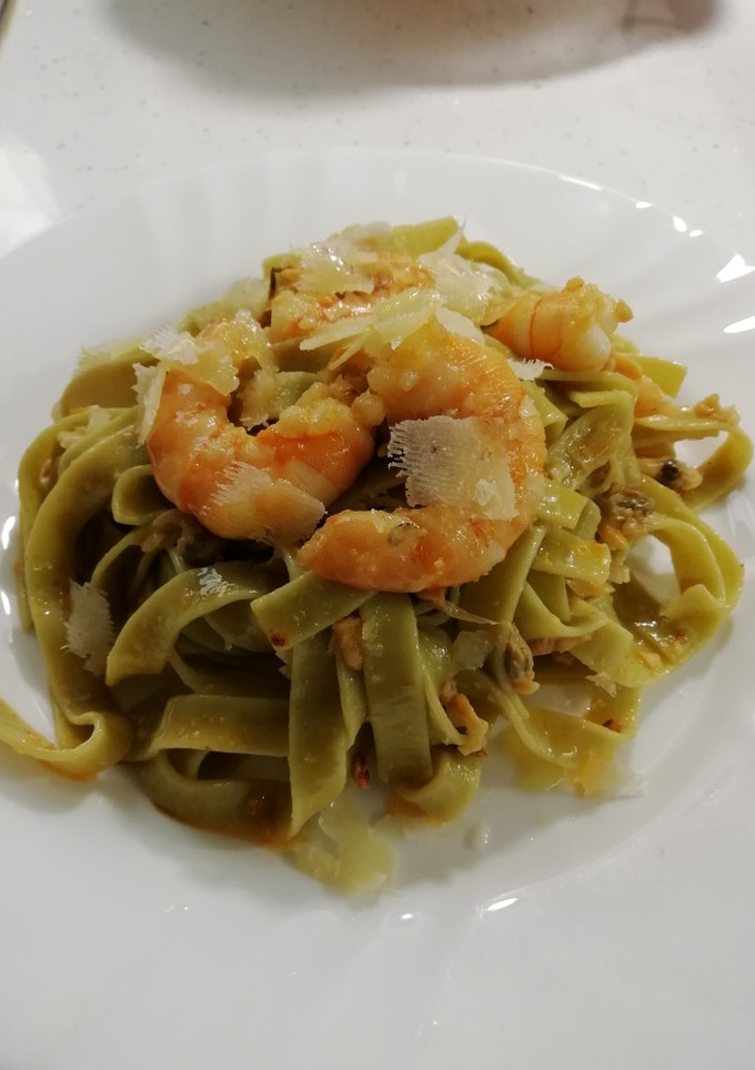 Una foto de Tagliatelle con almejas, langostinos y lascas de queso curado