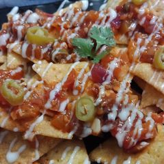A picture of Cornitos with tomato salsa and cheese sauce.