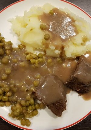 Una foto de Carne al vino - Acompañado con arvejas salteadas y puré
