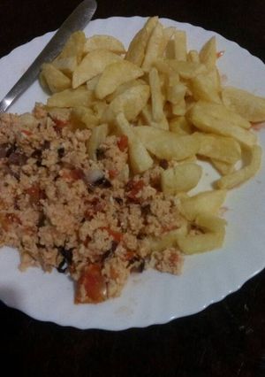 A picture of French fries with scrambled egg.