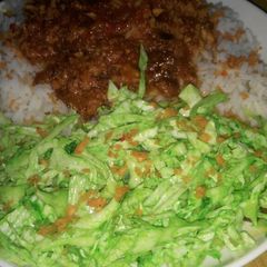 A picture of White rice and stew with simple colour salad.