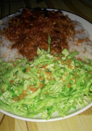 A picture of White rice and stew with simple colour salad.
