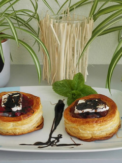 Una foto de Hojaldre con cebolla caramelizada, mermelada de higos o frutos rojos, queso de cabra y reducción de vinagre de módena