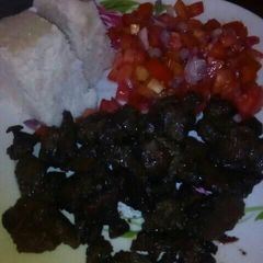 A picture of Fried liver with ugali and kachumbari.