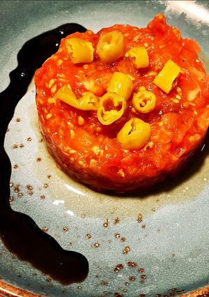 Una foto de Tartar de tomate azul, guindilla y concentrado balsámico