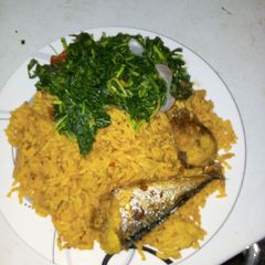 Jollof rice with fried fish and vegetable A picture of Jollof rice with fried fish and vegetable.
