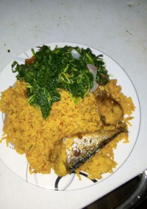 A picture of Jollof rice with fried fish and vegetable.