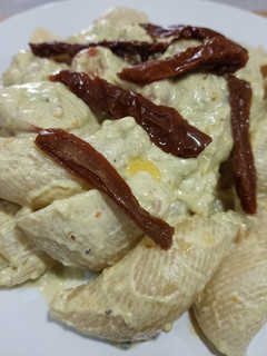 Una foto de Lumaconis con salsa de aguacate, piñones y cherrys