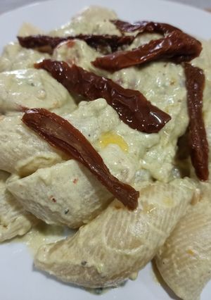 Una foto de Lumaconis con salsa de aguacate, piñones y cherrys