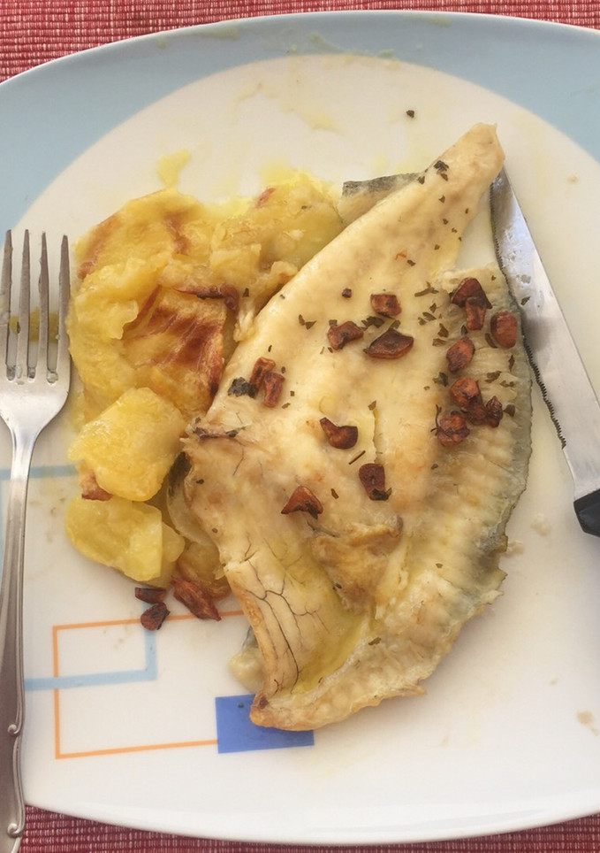 Una foto de Lomo de rodaballo al horno con patatas panadera y refrito de ajos