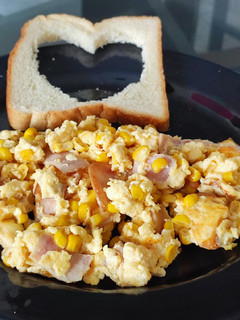 Una foto de Huevos revueltos con maíz, jamón y queso