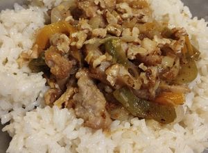Una foto de Muslos de pollo deshuesados con tandoori y nuez sobre arroz blanco