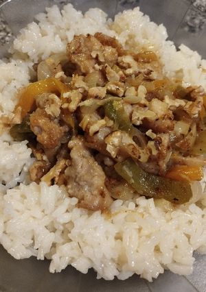 Una foto de Muslos de pollo deshuesados con tandoori y nuez sobre arroz blanco