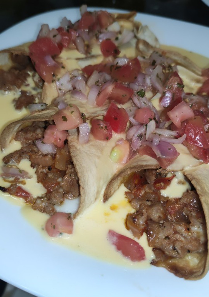 Una foto de Tacos de ternera bañados en queso cheddar
