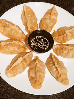 Una foto de Gyozas de pollo y verduras marinadas con teriyaky