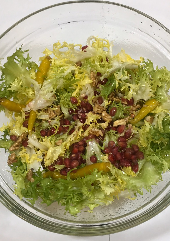 Una foto de Ensalada de escarola rizada con granada y piparras