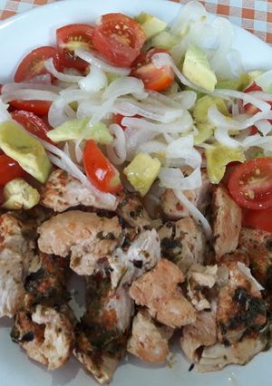 Una foto de Cubitos de pollo con ensalada de palta, cebolla y tomates 💕