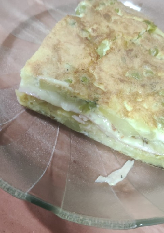 Una foto de Tortilla de papa rellena de jamón queso y arvejas