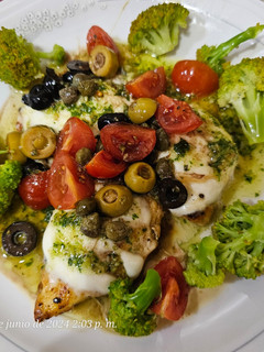 Una foto de Pollo con pesto de rúcula y ensalada de cherry