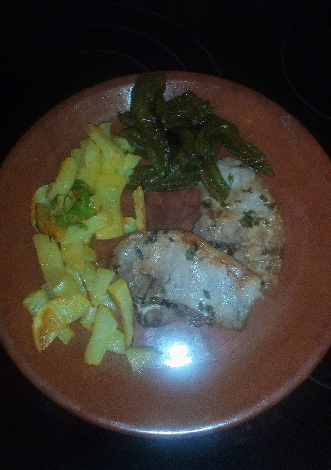 Una foto de Chuletas de lomo con pimientos y patatas fritas al horno