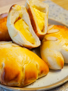 Una foto de Pan relleno de crema pastelera (クリームパン) / Bollo japonés