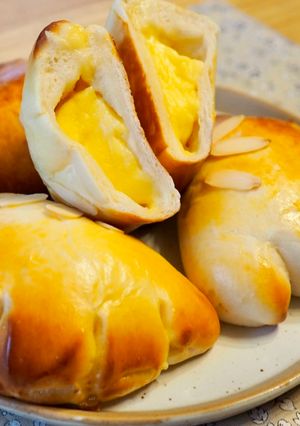 Una foto de Pan relleno de crema pastelera (クリームパン) / Bollo japonés
