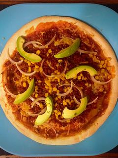 Una foto de Pizza de chorizo parrillero, millo y aguacate
