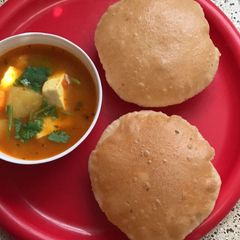 A picture of Aloo jhol and ajwain puri.