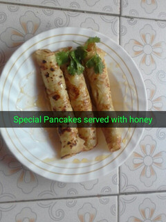 A picture of Sweet pancake served with honey.