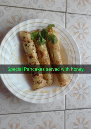 A picture of Sweet pancake served with honey.