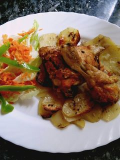 Una foto de Muslos de pollo sobre cama de patatas