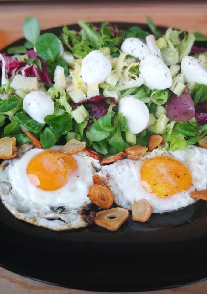 Una foto de Huevos fritos con ajo y ensalada