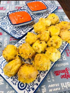 Una foto de Buñuelos de patata y queso con salsa de piquillos