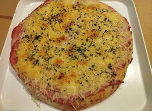 Una foto de Pizza margarita con jamón cocido y queso