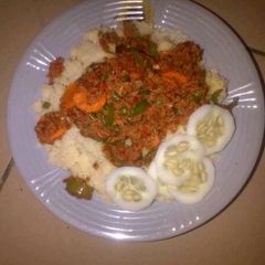 A picture of Couscous with meat sauce and cucumber.