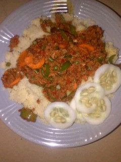 A picture of Couscous with meat sauce and cucumber.
