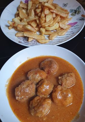 A picture of Meatballs in Sauce with French Fries.