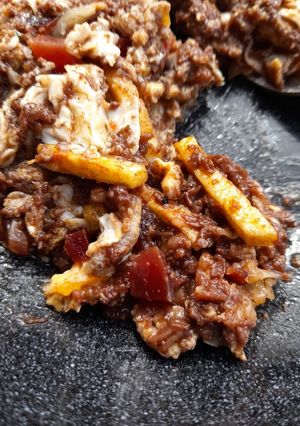Una foto de Revuelto de morcilla con jamón y patatas paja