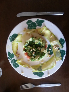 Una foto de Tartar de aguacate y tomate con calabacín braseado y piñones