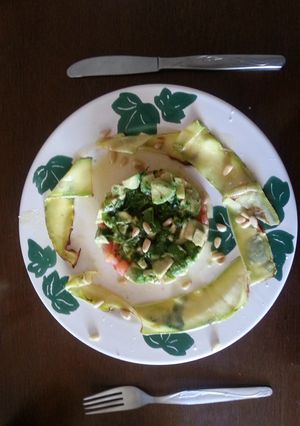 Una foto de Tartar de aguacate y tomate con calabacín braseado y piñones 