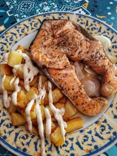 Una foto de Salmón especiado con patatas y cebolla