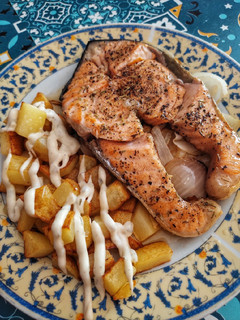 Una foto de Salmón especiado con patatas y cebolla