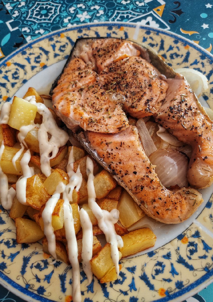 Una foto de Salmón especiado con patatas y cebolla